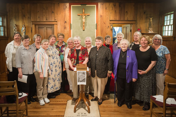 Loretto Sisters and friends with Badin's Bible in the Log Chapel
