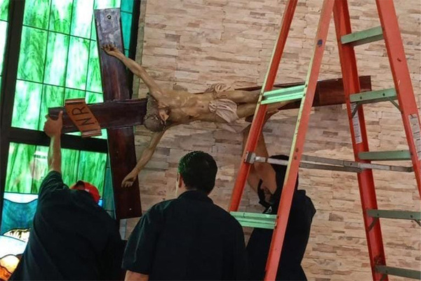 UCA staff remove a crucifix for safekeeping. 