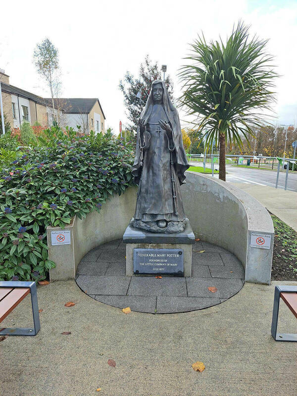 Bronze statue of Venerable Mary Potter, foundress of the Little Company of Mary, holding a rosary. A plaque identifies her and notes the founding date of July 1877.